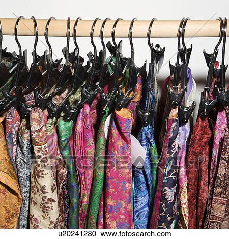 Stock Image - Colorful clothes hanging on rack.. Fotosearch
