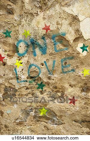 Picture - Concrete wall with graffiti stating 'One Love'. Fotosearch