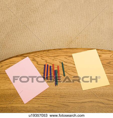 Stock Image - Construction paper and crayons on table. Fotosearch