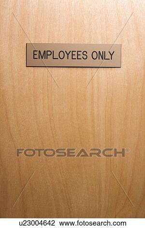 Stock Image - Employees only sign on wooden door. Fotosearch