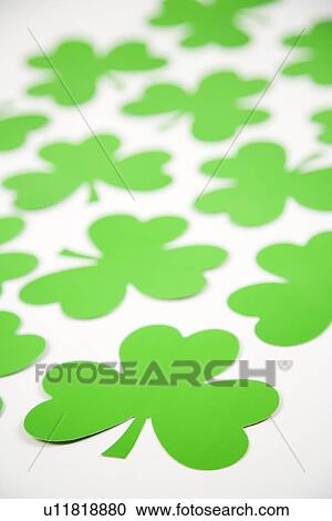 Stock Image - Group of green paper shamrocks on white. Fotosearch