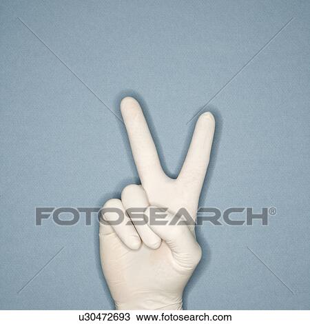 Stock Image - Hand wearing white rubber glove making a gesture meaning peace. Fotosearch