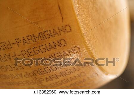 Stock Image - Hunk of stamped parmigiano cheese. Fotosearch