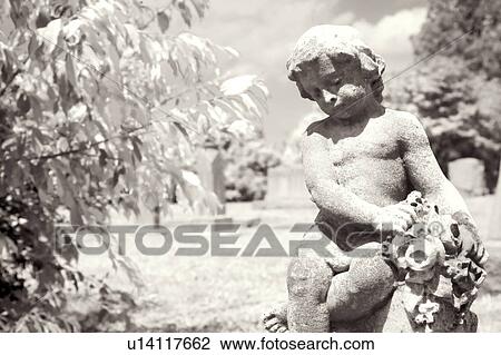 Stock Image - Infrared graveyard scenic with cherub statue. Fotosearch