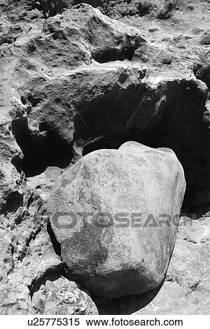 Stock Photography - Large lava rock setting on rock cliff wall in Maui, Hawaii. Fotosearch