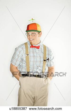Man dressed like nerd wearing propeller cap with hands in pockets View Large Photo Image Stock Photo - Man dressed like nerd wearing propeller cap with hands in pockets. Fotosearch