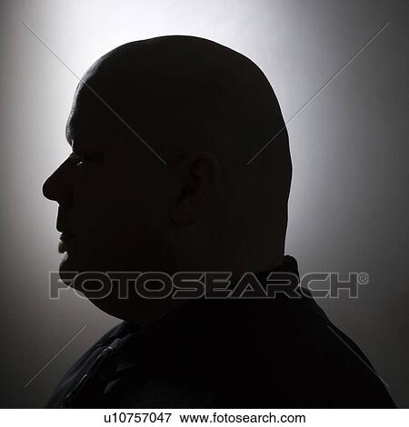 Stock Photo - Mid adult bald man in silhouette. Fotosearch