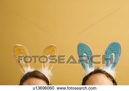 Stock Image - Mid adult couple wearing rabbit ears.. Fotosearch
