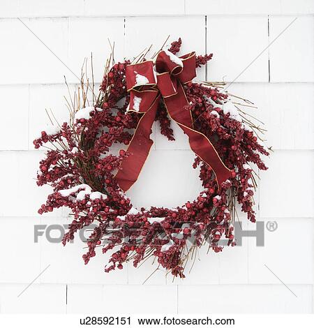 Red wreath covered in snow hanging on a white brick wall View Large Photo Image Stock Image - Red wreath covered in snow hanging on a white brick wall. Fotosearch