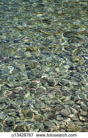 Rocks seen through rippling clear water View Large Photo Image Stock Photo - Rocks seen through rippling clear water. Fotosearch