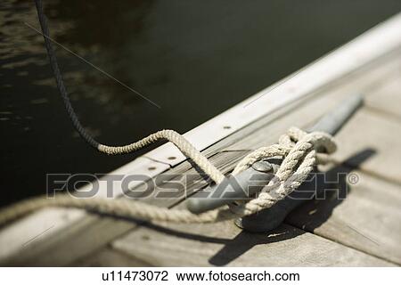 Rope tied to cleat on boat dock View Large Photo Image Stock Image - Rope tied to cleat on boat dock. Fotosearch