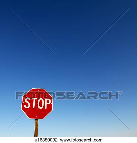 Stock Image - Stop sign in lower left corner with blue sky all around. Fotosearch