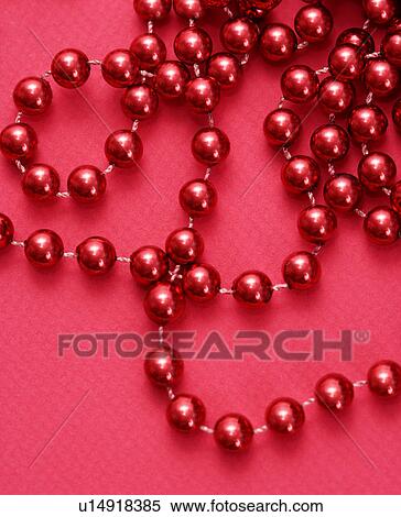 Stock Photography - String of red beads on red background. Fotosearch