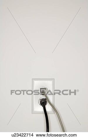 Picture - Two cords plugged into electrical wall outlet. Fotosearch