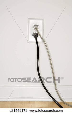 Stock Photo - Two cords plugged into electrical wall outlet. Fotosearch