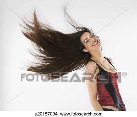 Picture - Woman wearing corset swinging her hair. Fotosearch
