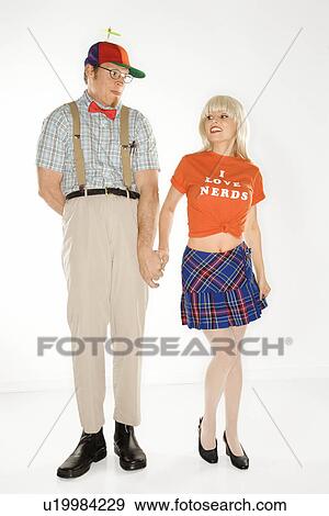 Stock Photo - Young man dressed like nerd holding hands with young woman wearing tshirt reading I love nerds. Fotosearch