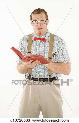 Stock Image - Young man dressed like nerd with book open, looking at viewer. Fotosearch