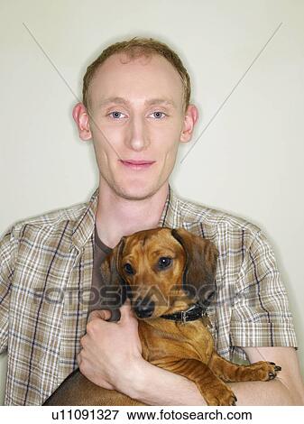 Stock Photo - Portrait of young man with dog. Fotosearch