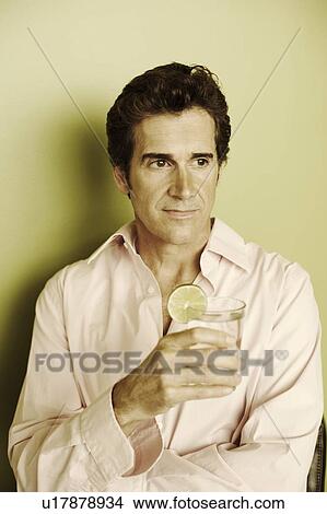Close-up of a mature man holding a glass View Large Photo Image Picture - Close-up of a mature man holding a glass. Fotosearch