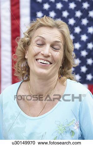 Stock Image - Close-up of a mature woman smiling with her eyes closed. Fotosearch