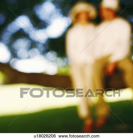Stock Photograph - Couple sitting on a tree. Fotosearch
