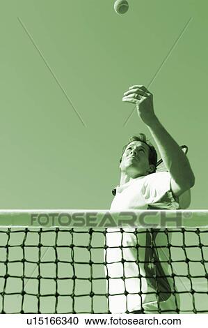 Low angle view of a mid adult man playing tennis View Large Photo Image Stock Image - Low angle view of a mid adult man playing tennis. Fotosearch