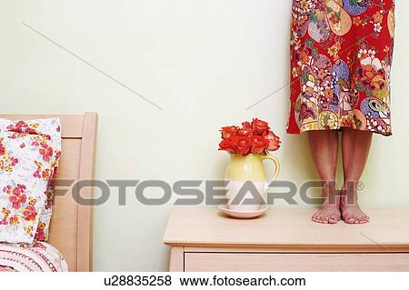 Low section view of a woman standing on a cabinet View Large Photo Image Stock Photo - Low section view of a woman standing on a cabinet. Fotosearch