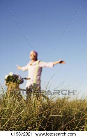 Mature woman standing with her arms outstretched View Large Photo Image Stock Image - Mature woman standing with her arms outstretched. Fotosearch