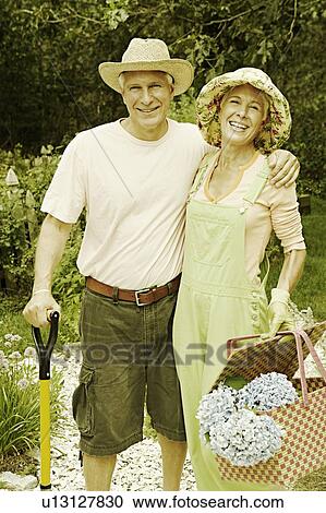 Portrait of a mature man and a senior woman standing in a garden and smiling View Large Photo Image Stock Image - Portrait of a mature man and a senior woman standing in a garden and smiling. Fotosearch