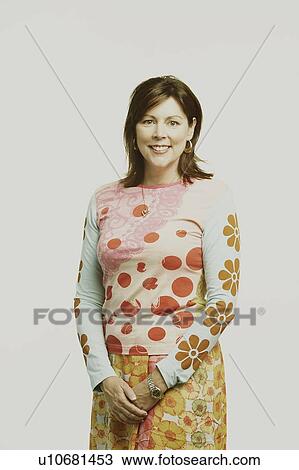 Portrait of a mature woman standing and smiling View Large Photo Image Stock Image - Portrait of a mature woman standing and smiling. Fotosearch