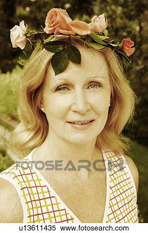 Portrait of a mature woman wearing a crown of flowers and smiling View Large Photo Image Stock Photography - Portrait of a mature woman wearing a crown of flowers and smiling. Fotosearch