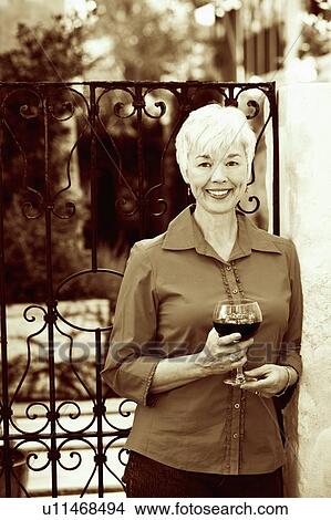 Portrait of a senior woman holding a glass of red wine View Large Photo Image Picture - Portrait of a senior woman holding a glass of red wine. Fotosearch