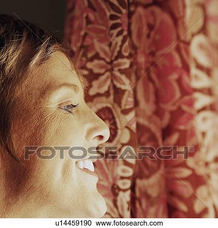 Stock Image - Side profile of a mature woman smiling. Fotosearch