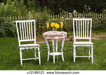 Stock Image - Two chairs and a table in a garden. Fotosearch