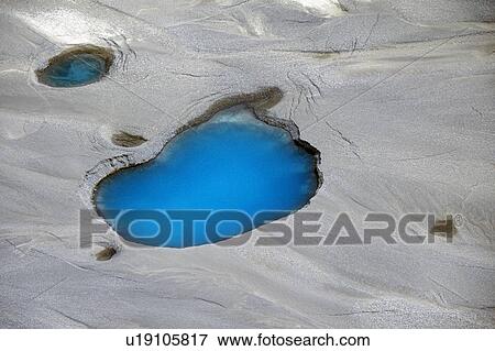 Stock Photo - Aerial view of silt and turquoise water in an Alaska glacier. Fotosearch