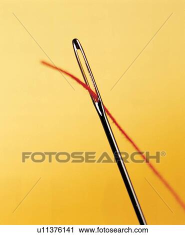 Stock Image - fibers, detail, threaded, needle, pin, eye, yellow background. Fotosearch