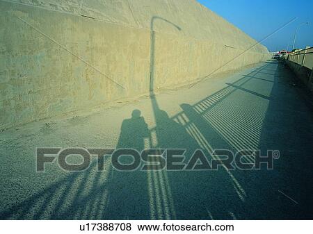 Stock Photo - sun light, road, shadow, railings. Fotosearch