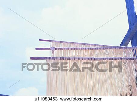 Stock Image - outdoor, noodles, wood stick, sky, village, farm. Fotosearch