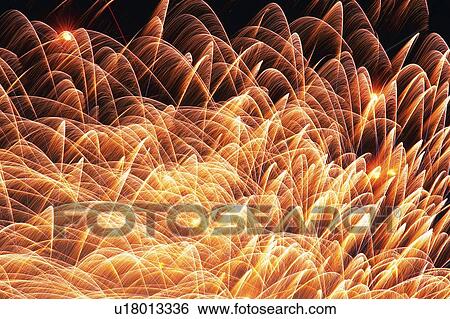Stock Photograph -  Gold-colored Fireworks Exploding in the Night Sky, Long Exposure, Low Angle View . Fotosearch