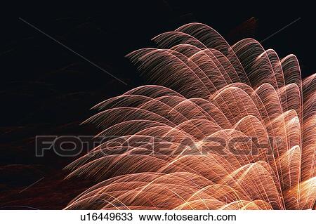 Stock Image -  Light Pink-colored Fireworks Exploding in the Night Sky, Long Exposure, Low Angle View. Fotosearch