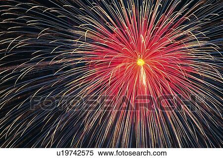 Stock Photography -  One Single Red and White-colored Exploding Fireworks, Spreading Across the Surface, Low Angle View, Long Exposure. Fotosearch