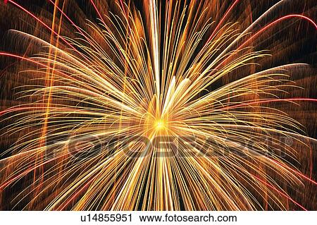 Stock Image -  Orange and Red-colored Fireworks Exploding in the Sky, Low Angle View, Long Exposure. Fotosearch