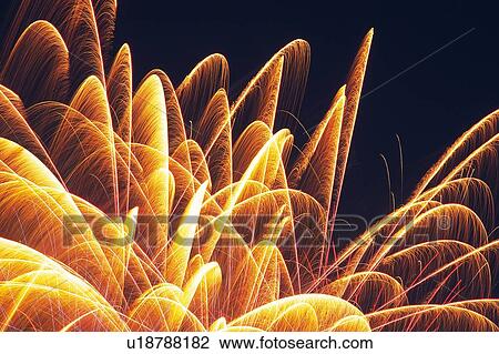 Stock Image -  Orange-colored Fireworks Exploding in the Night Sky, Long Exposure, Low Angle View . Fotosearch