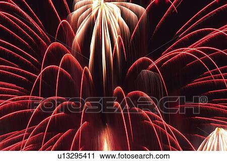 Stock Image -  Pink and White-colored Fireworks, Exploding in the Night Sky, Long Exposure, Low Angle View. Fotosearch
