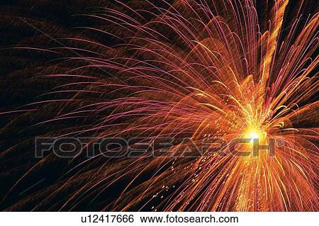 Stock Photograph -  Red-colored Fireworks Exploding in the Night Sky, Long Exposure, Low Angle View. Fotosearch