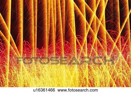 Stock Photograph -  Red, Yellow and Orange-colored Lined Up Fireworks Exploding in the Night Sky, Long Exposure . Fotosearch