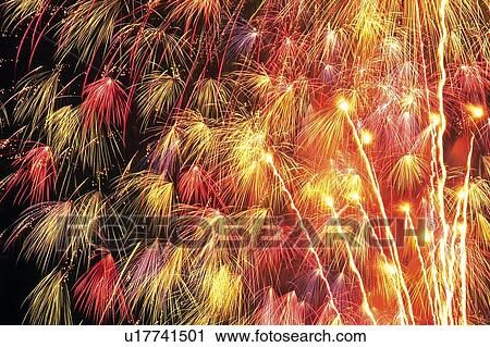 Stock Image -  Several Multicolored Fireworks Exploding in the Night Sky, Long Exposure, Low Angle View. Fotosearch