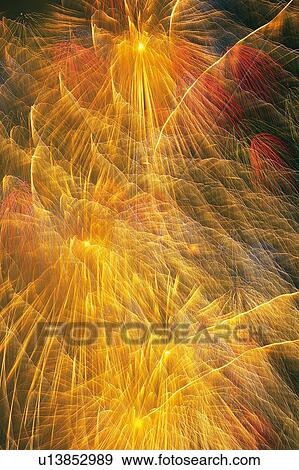Stock Photo -  Yellow and Red-colored Fireworks Exploding in the Night Sky, Long Exposure, Low Angle View . Fotosearch