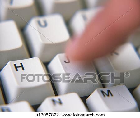 Stock Image - A finger pressing a keyboard, Close Up, High Angle View, Blurred Motion. Fotosearch